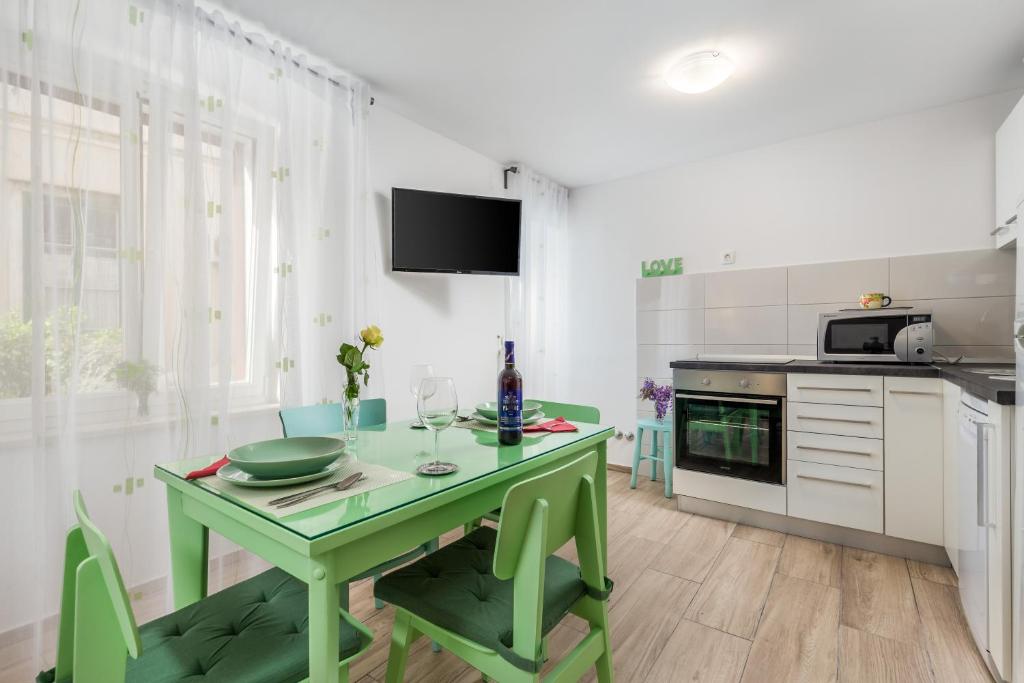 a kitchen with a green table and a green chair at Adeona apartments in Rijeka