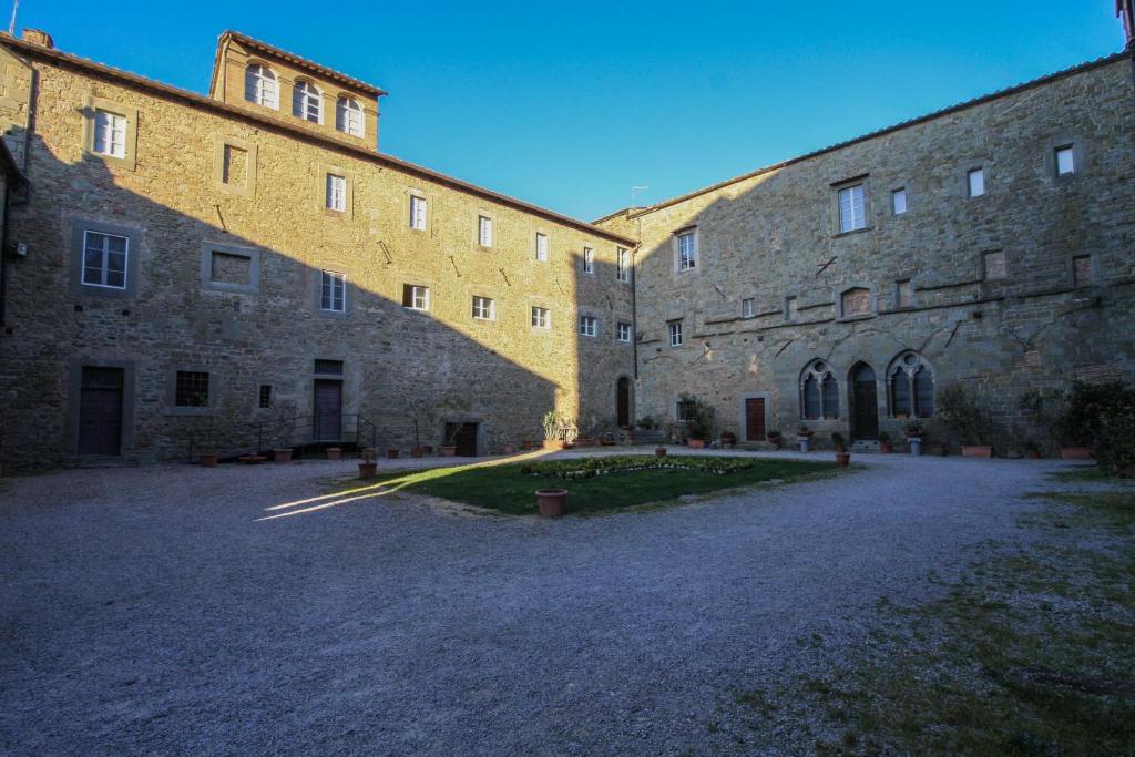 a large brick building with a courtyard in front of it at B&B San Francesco in Cortona