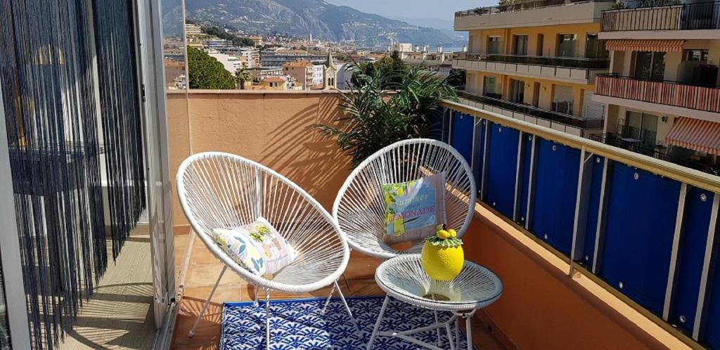 a balcony with two chairs and a vase on it at Au Citron du Cap in Roquebrune-Cap-Martin