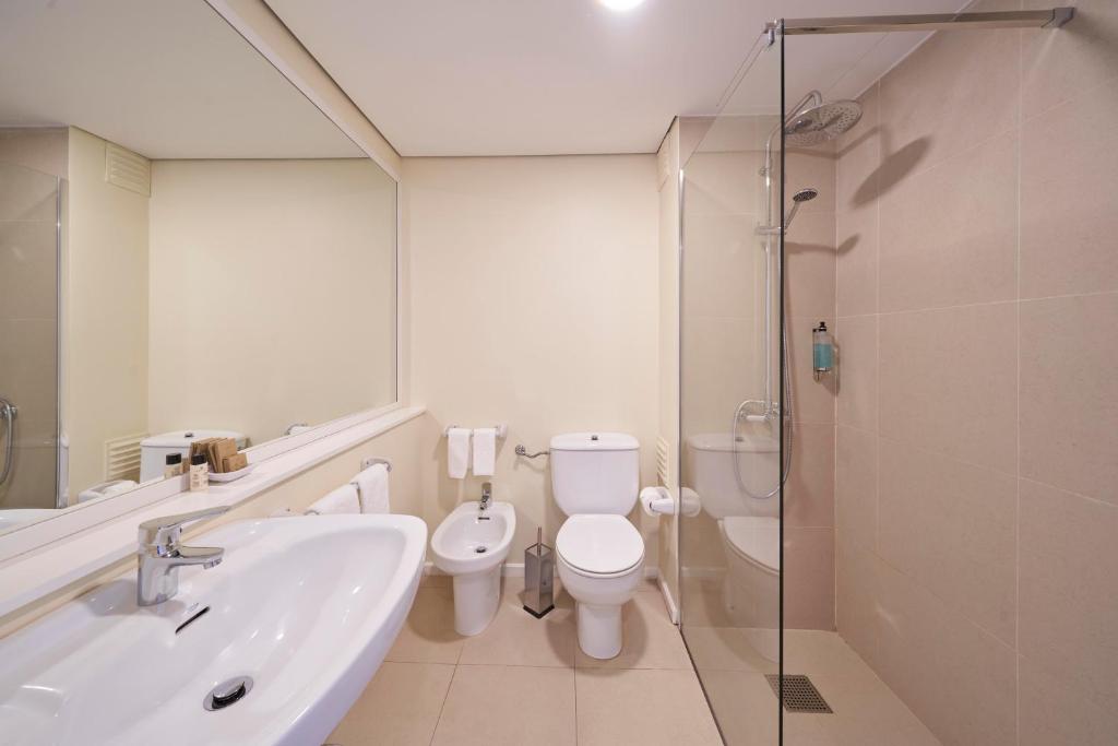 a bathroom with a sink and a toilet and a shower at Hotel Porto Santo & Spa in Porto Santo