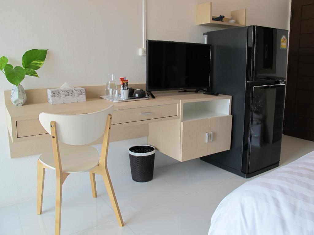 a desk with a tv and a chair in a room at J.K. Mansion in Bangkok