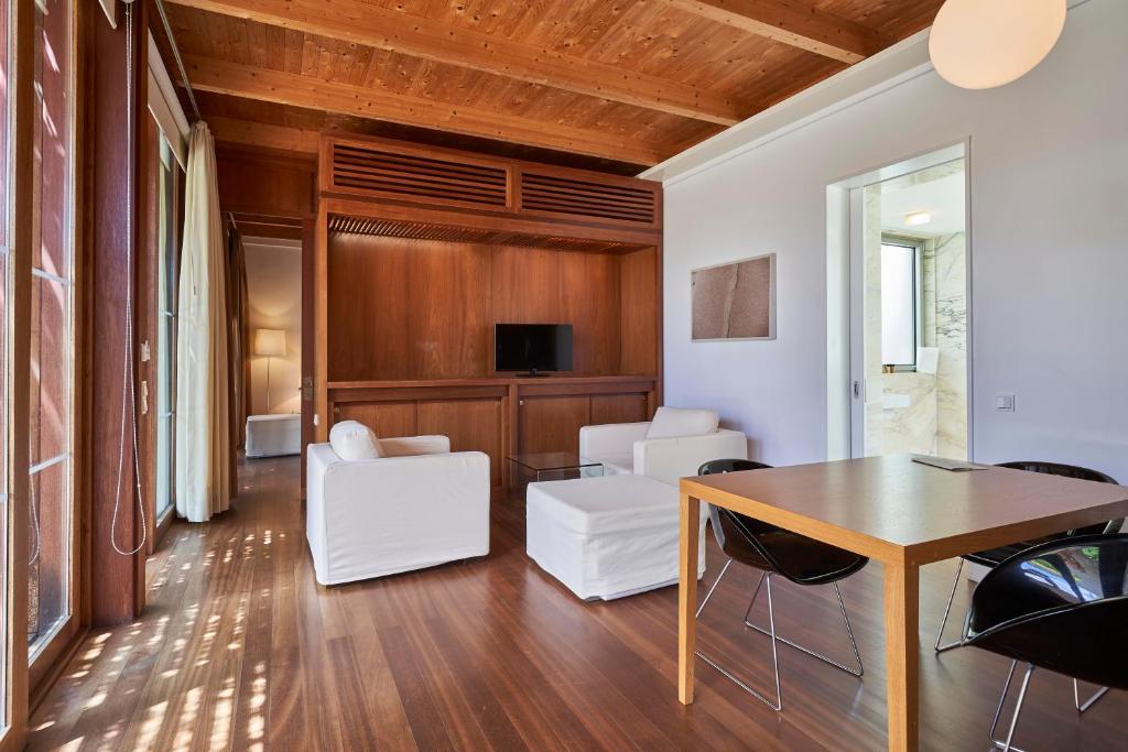 a living room with white chairs and a table at Hotel Porto Santo & Spa in Porto Santo