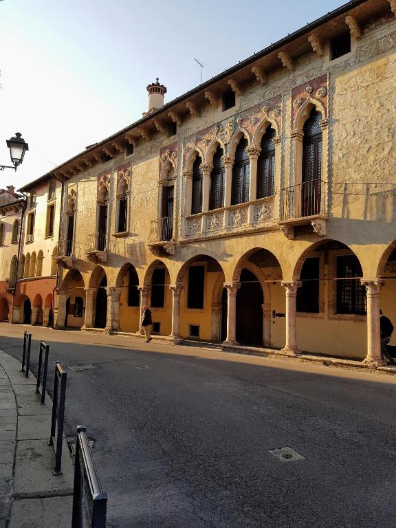 an old building with arches on the side of a street at B&B Palazzo Regaù in Vicenza
