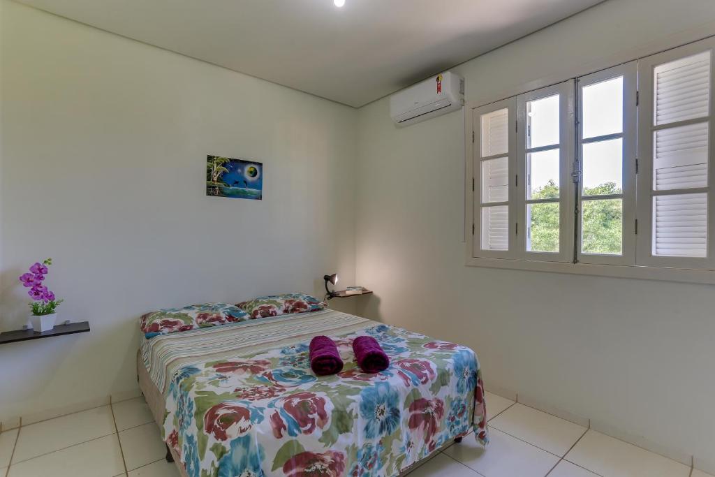 a bedroom with a bed with pink shoes on it at Águas de Verão in Florianópolis