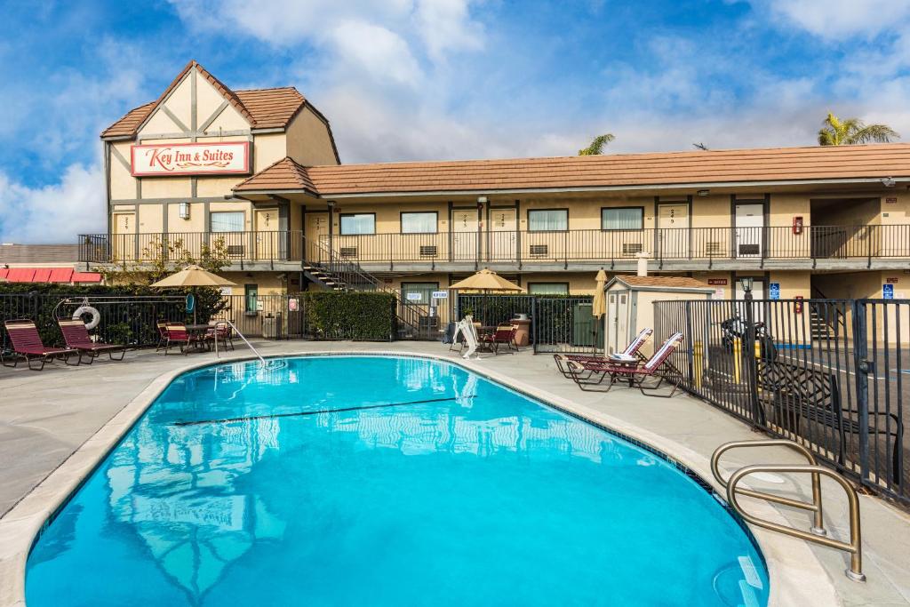 a hotel with a swimming pool in front of a building at Key Inn and Suites in Tustin