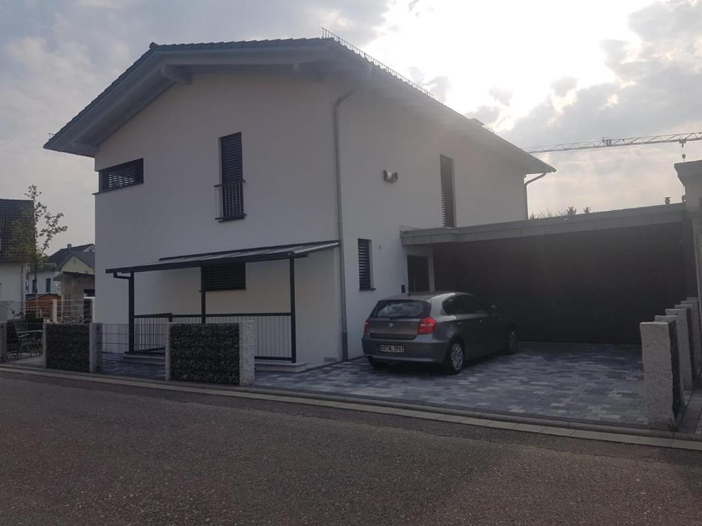 um carro estacionado em frente a uma casa branca em FeWo bei Alex em Ettenheim