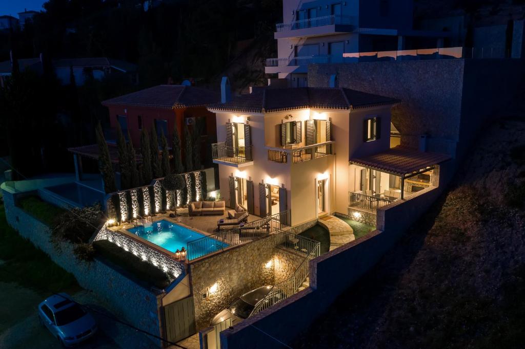 an aerial view of a house with a swimming pool at night at Villa Giannanti in Porto Heli