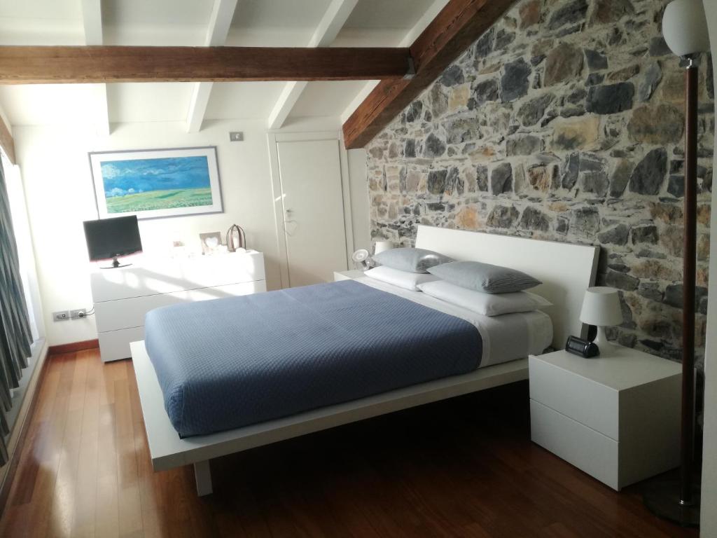 1 dormitorio con cama y pared de piedra en La Pietra del Golfo, en La Spezia