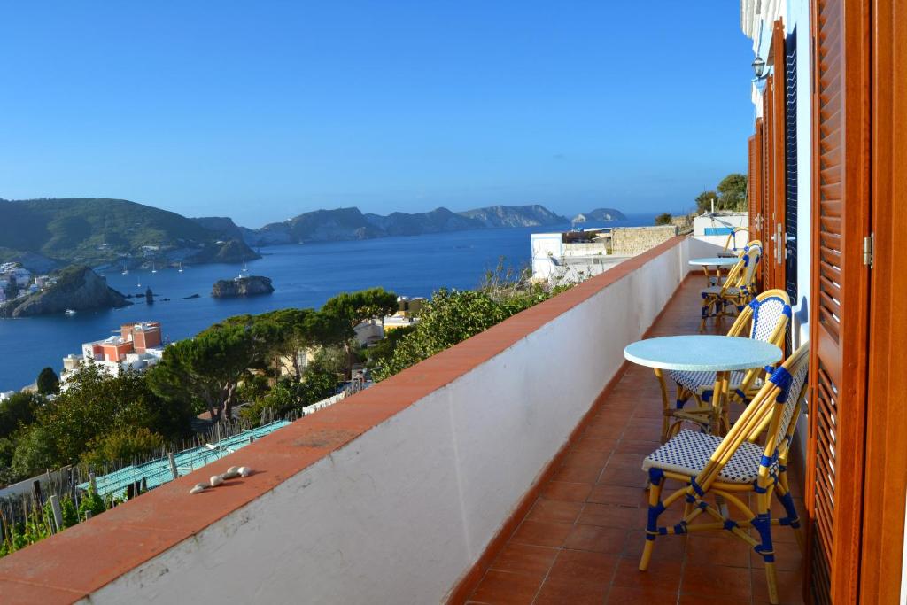 een balkon met een tafel en stoelen en uitzicht op het water bij Maridea - Villa Mariella in Ponza