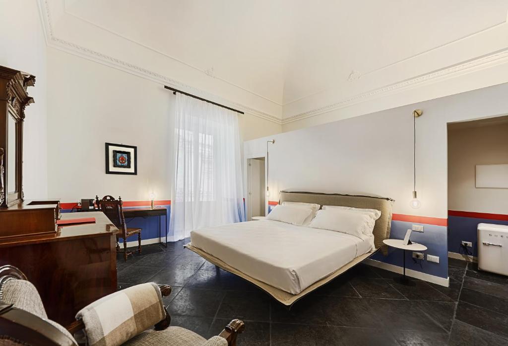 een slaapkamer met een bed en een bureau. bij A.D. 1768 Boutique Hotel in Ragusa