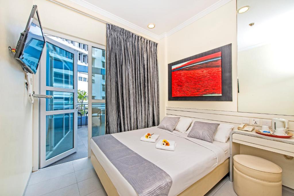 um quarto com uma cama e uma grande janela em Hotel 81 Elegance em Singapura