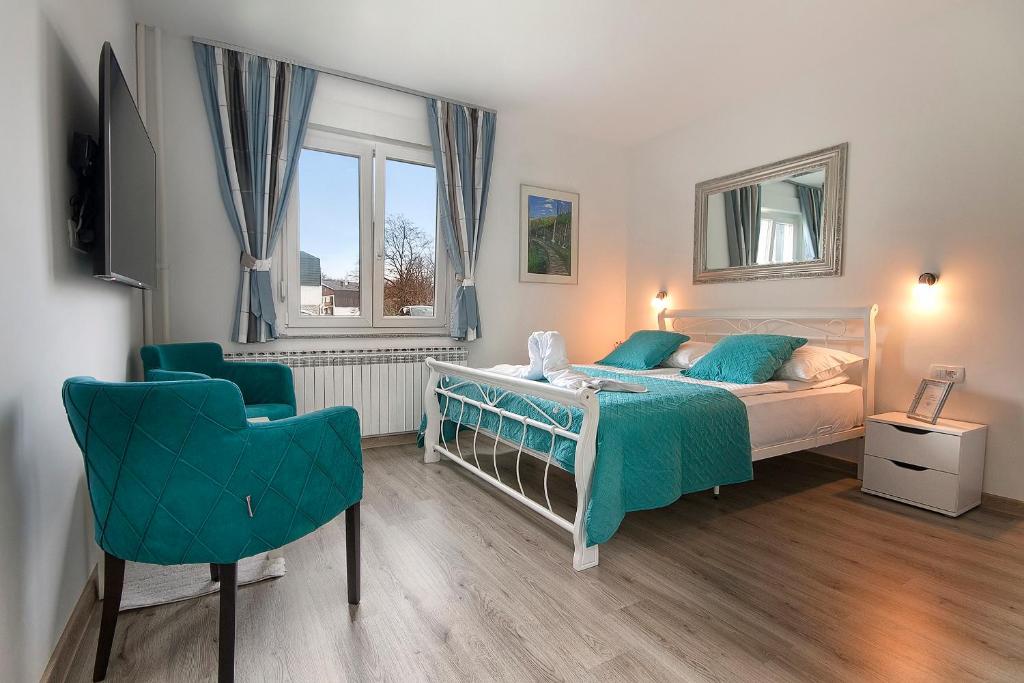 um quarto com uma cama e uma cadeira em Emerald Luxury Apartments em Plitvička Jezera