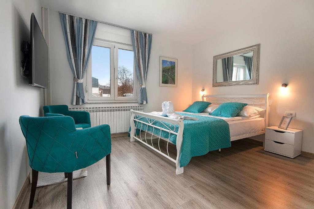 1 dormitorio con 1 cama y 1 silla en Emerald Luxury Apartments, en Lagos de Plitvice