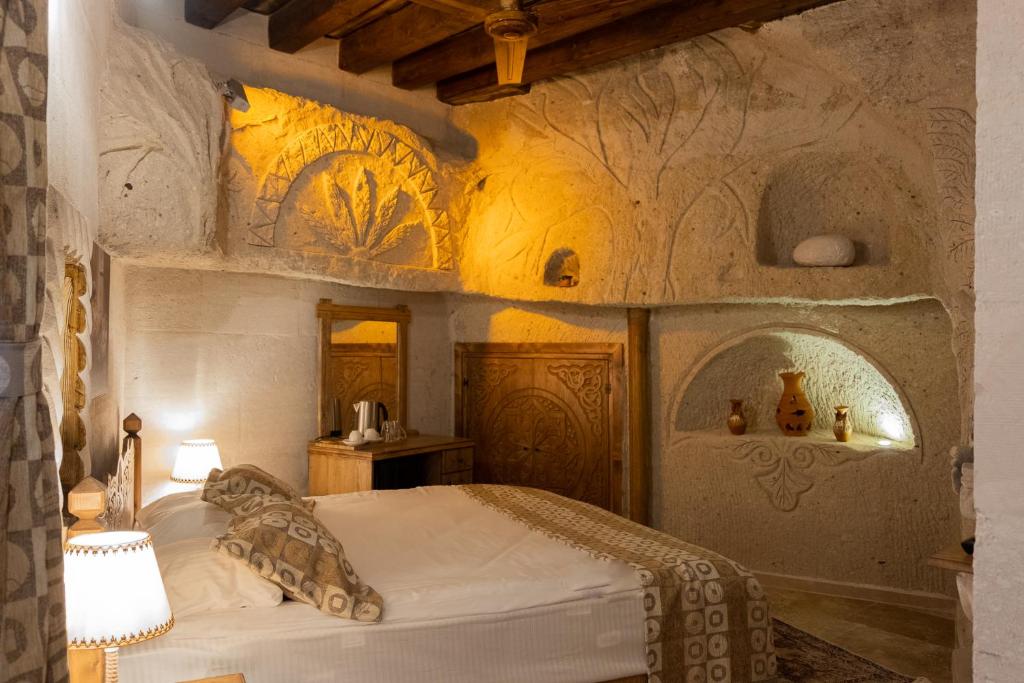 a bedroom with a bed and a wall with paintings at Grand Elite Cave Suites in Goreme