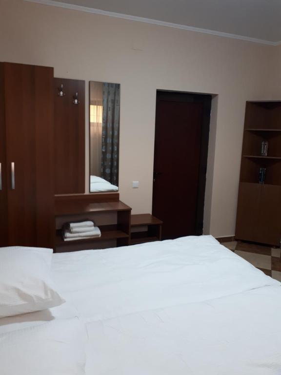 a bedroom with a white bed and a mirror at Victoria 1 in Campina