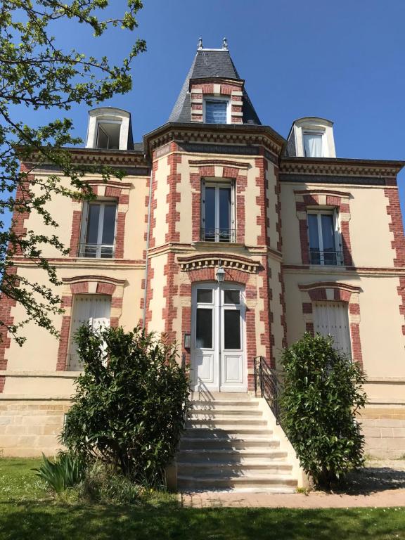 Una casa vieja con escaleras delante. en Villa st Louis, en Cabourg