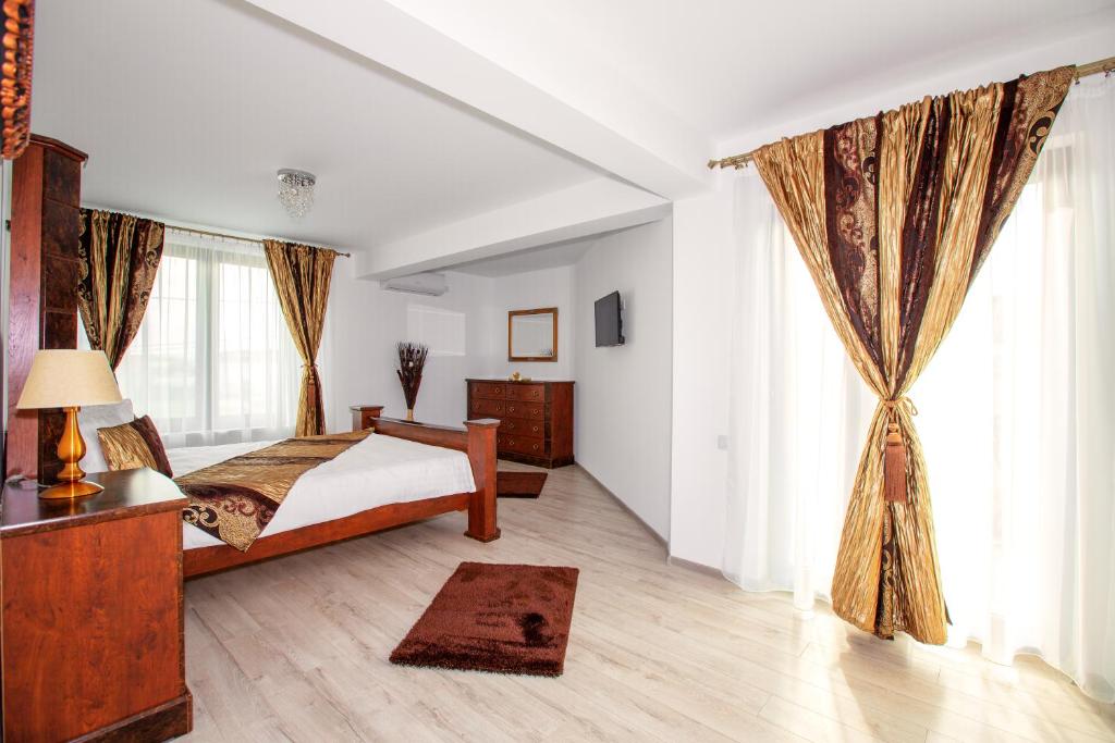 1 dormitorio con cama y ventana grande en Casa Romeo & Julieta, en Haţeg