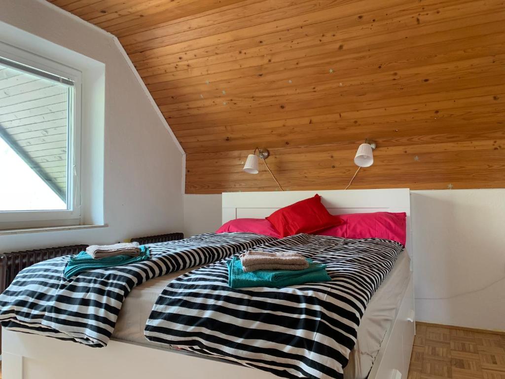 two beds in a room with a wooden ceiling at Entire house Iris & Arnika in Bled