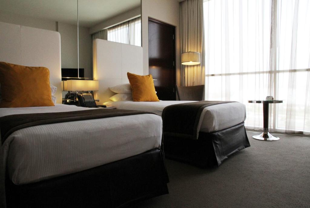 a hotel room with two beds and a large window at Centro Yas Island-by Rotana in Abu Dhabi