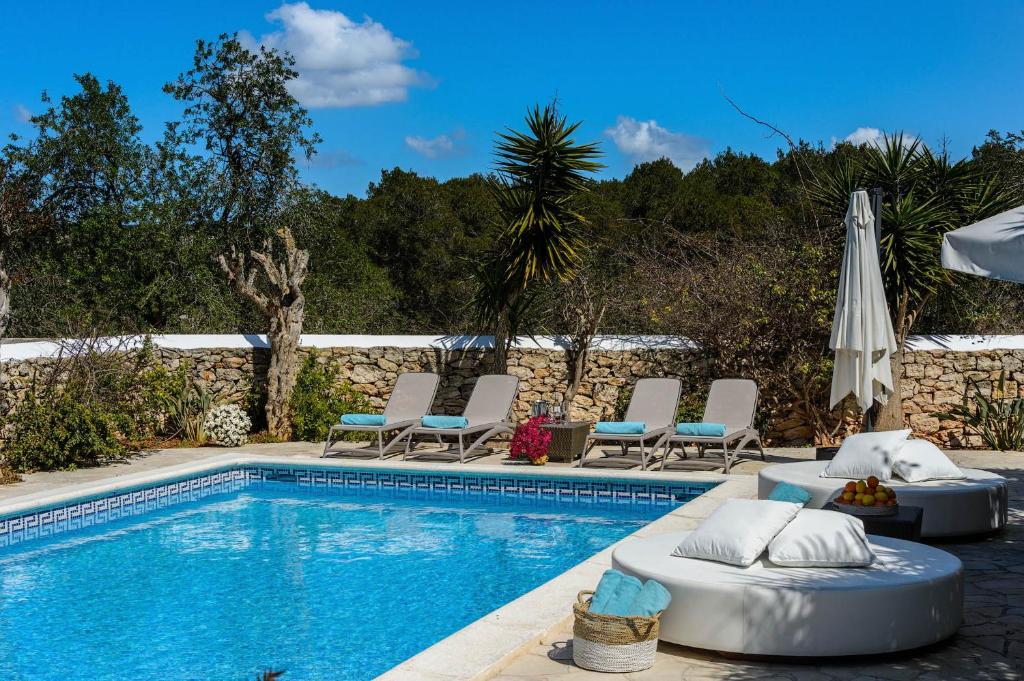 una piscina con tumbonas y sombrilla en Villa Can Fita, en Puig D’en Valls