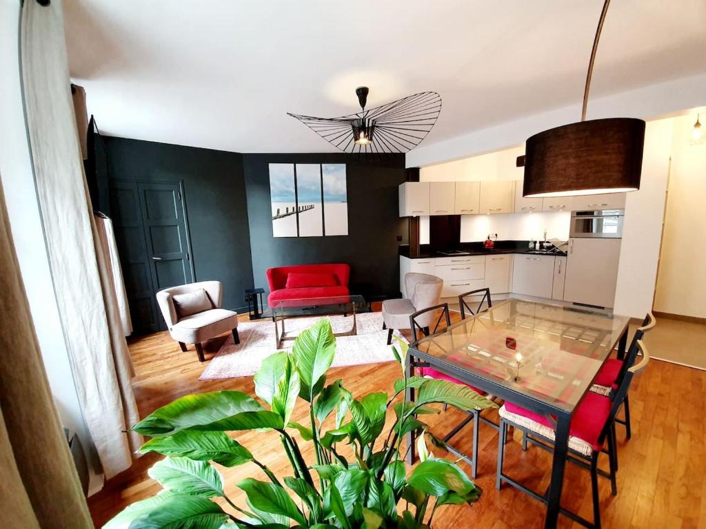 sala de estar con mesa de cristal y cocina en Le Pilo en Saint-Malo