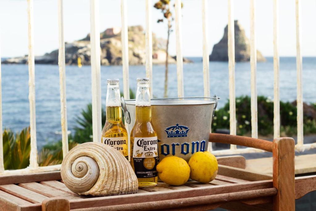 a table with bottles of beer and lemons on a balcony at Casa Galatea in Acitrezza