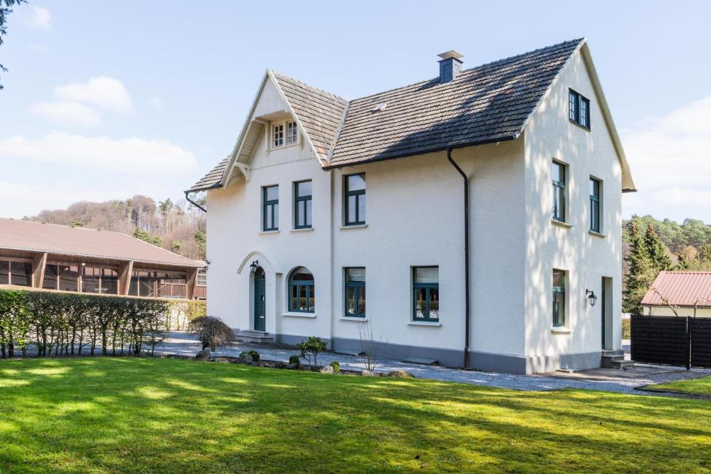 a white house with a large yard at Forsthaus Edelburg Ferienhaus in Hemer