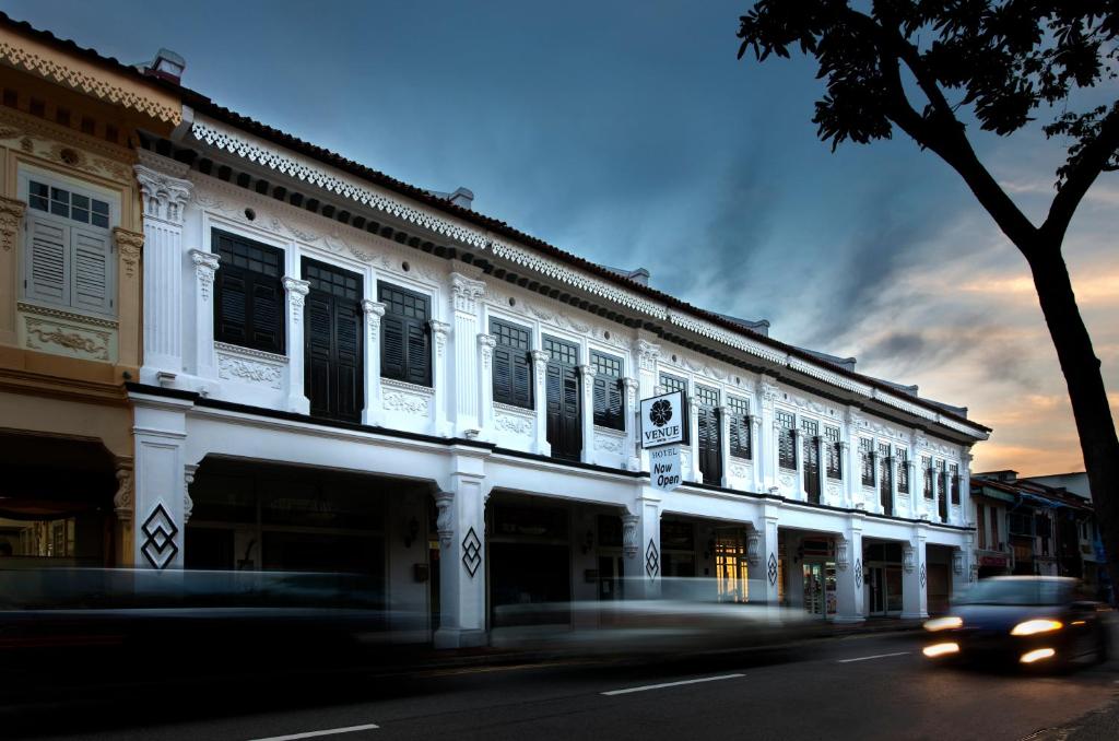 ein Gebäude auf einer Straße, an der ein Auto vorbeifährt in der Unterkunft Venue Hotel in Singapur