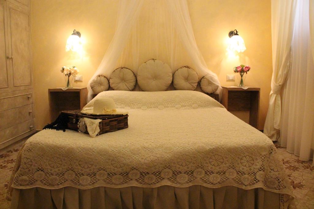 una camera da letto con un grande letto bianco con due luci di B&Bcasamalì a Selva di Fasano