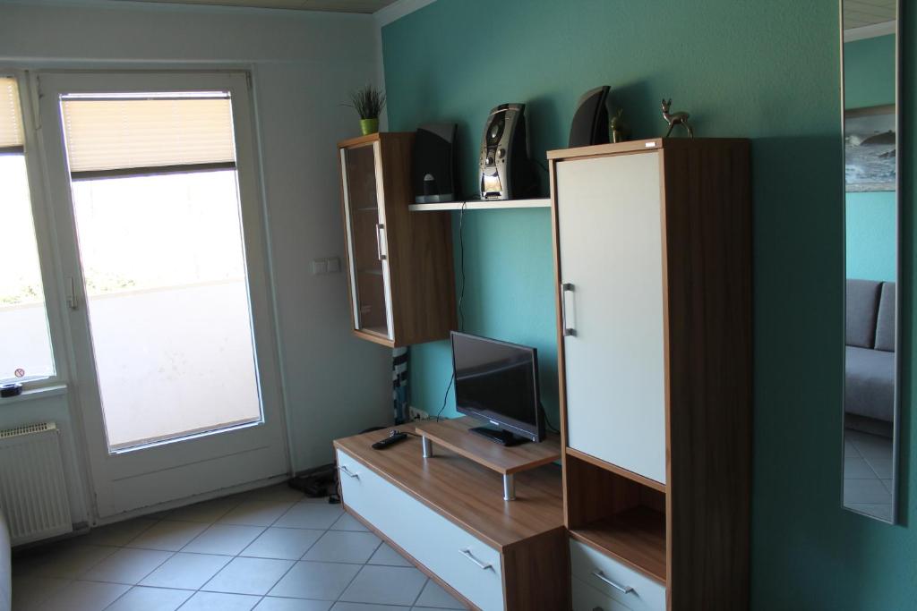 een kamer met een bureau, een televisie en een raam bij Ferienwohnung F127 an der Ostsee in Brasilien