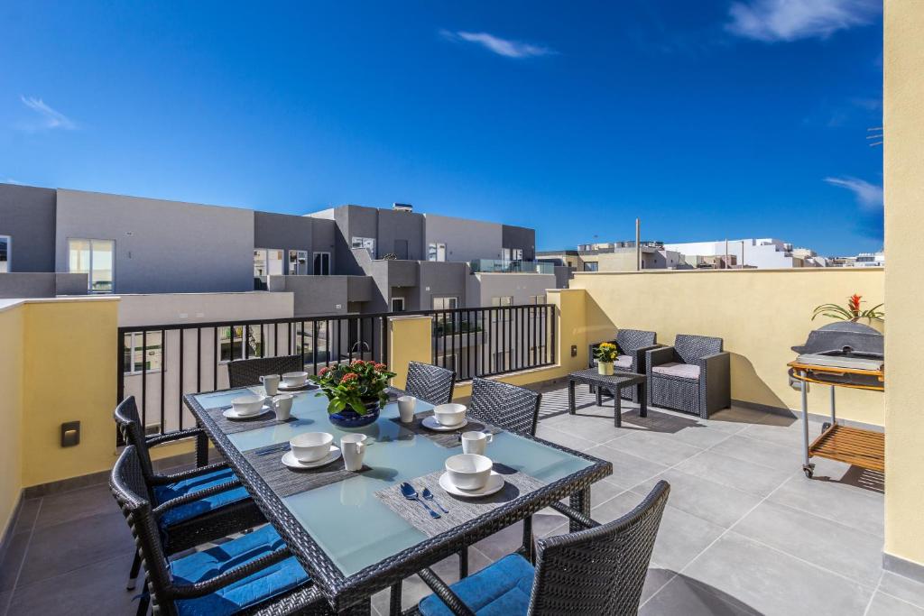 d'une terrasse avec une table et des chaises sur un balcon. dans l'établissement Sunny Modern Apartments, à Mellieħa