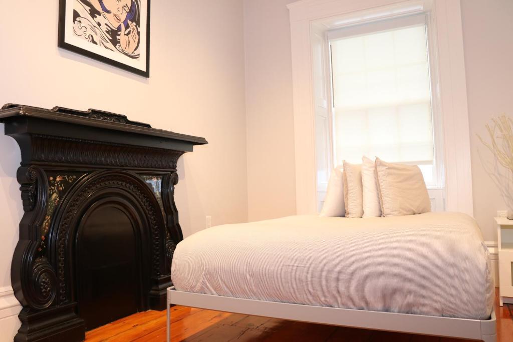 a bedroom with a bed with white sheets and a window at Charming & Stylish Studio on Beacon Hill #11 in Boston