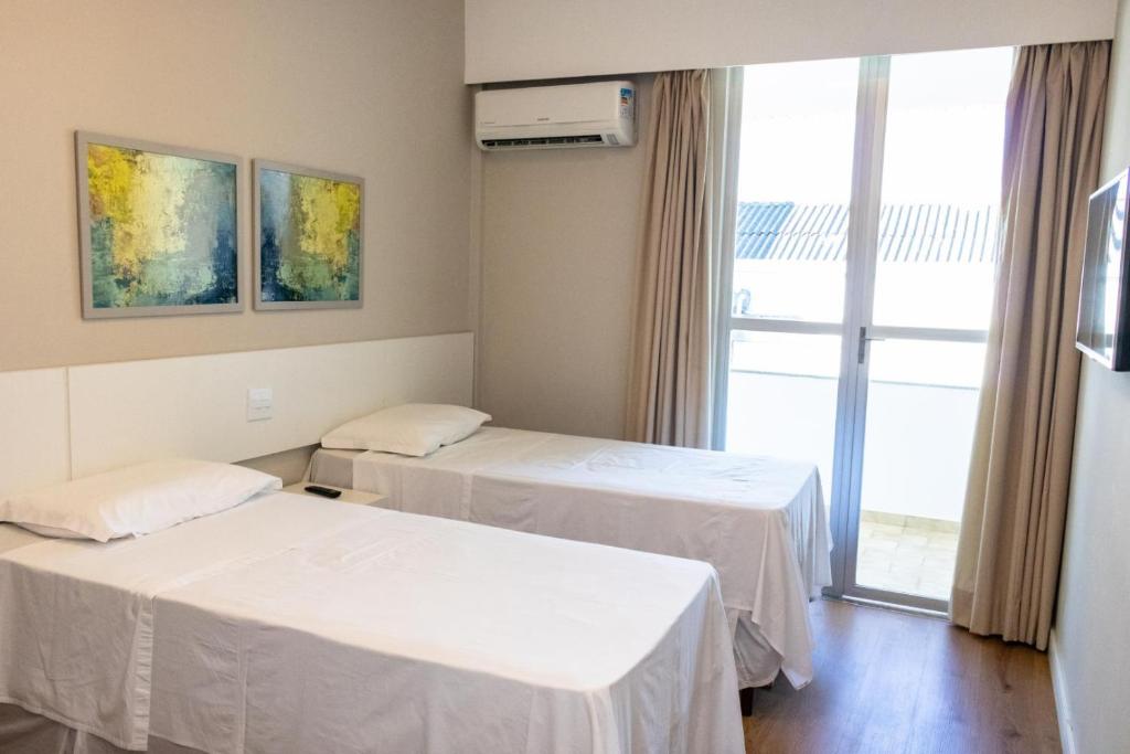 a hospital room with two beds and a window at Antonius Imperial Hotel in Santo Antônio de Jesus