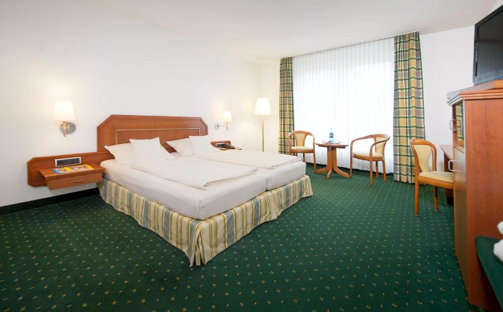 Postel nebo postele na pokoji v ubytování Maifeld Sport- und Tagungshotel