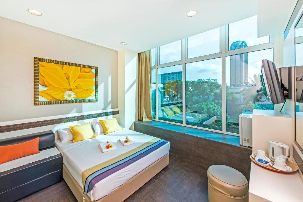 ein Hotelzimmer mit einem Bett und einem großen Fenster in der Unterkunft Hotel 81 Bugis in Singapur