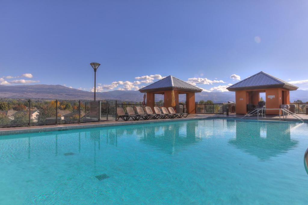 una gran piscina con sillas y cenador en Playa Del Sol Resort - Vacation Rentals, en Kelowna