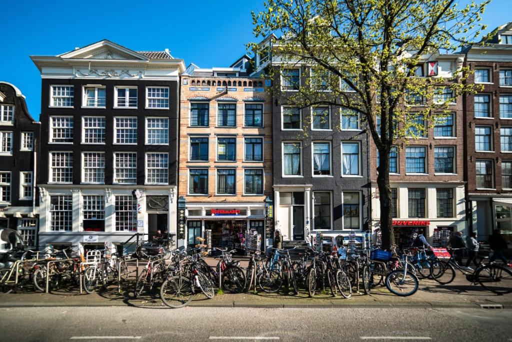 un montón de bicicletas estacionadas frente a los edificios en Beautiful DutchHouse Centrum en Ámsterdam