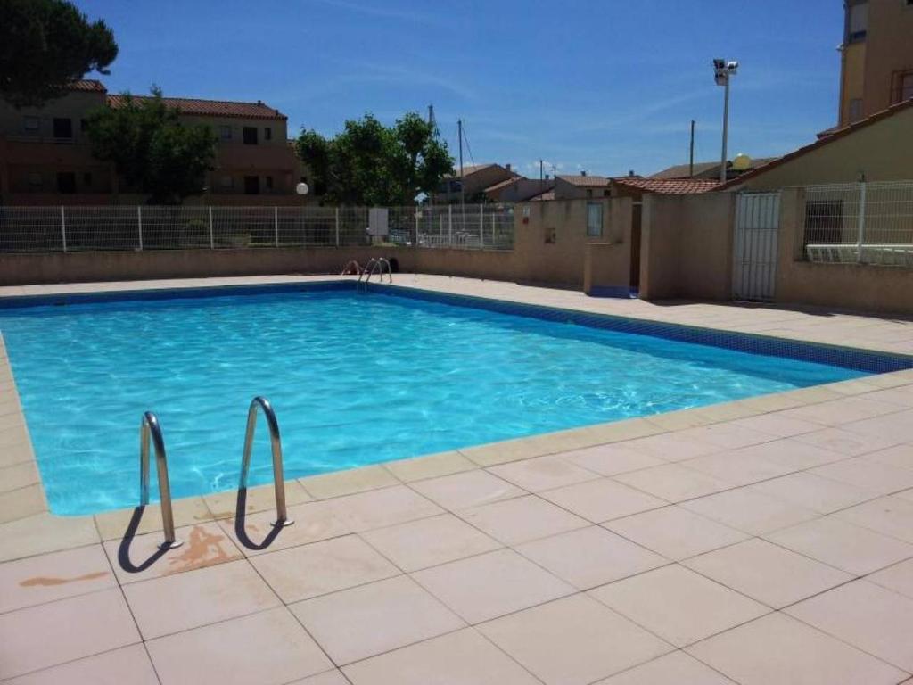 une grande piscine avec de l'eau bleue dans l'établissement AGREABLE VILLA DANS LA MARINA AVEC PISCINE, à Saint-Cyprien
