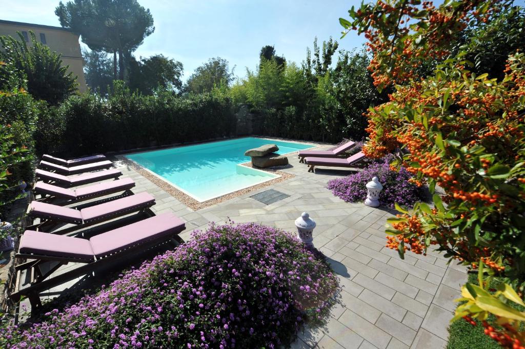 a swimming pool with lounge chairs and purple flowers at Residenza Villa Titina in SantʼAgata sui Due Golfi
