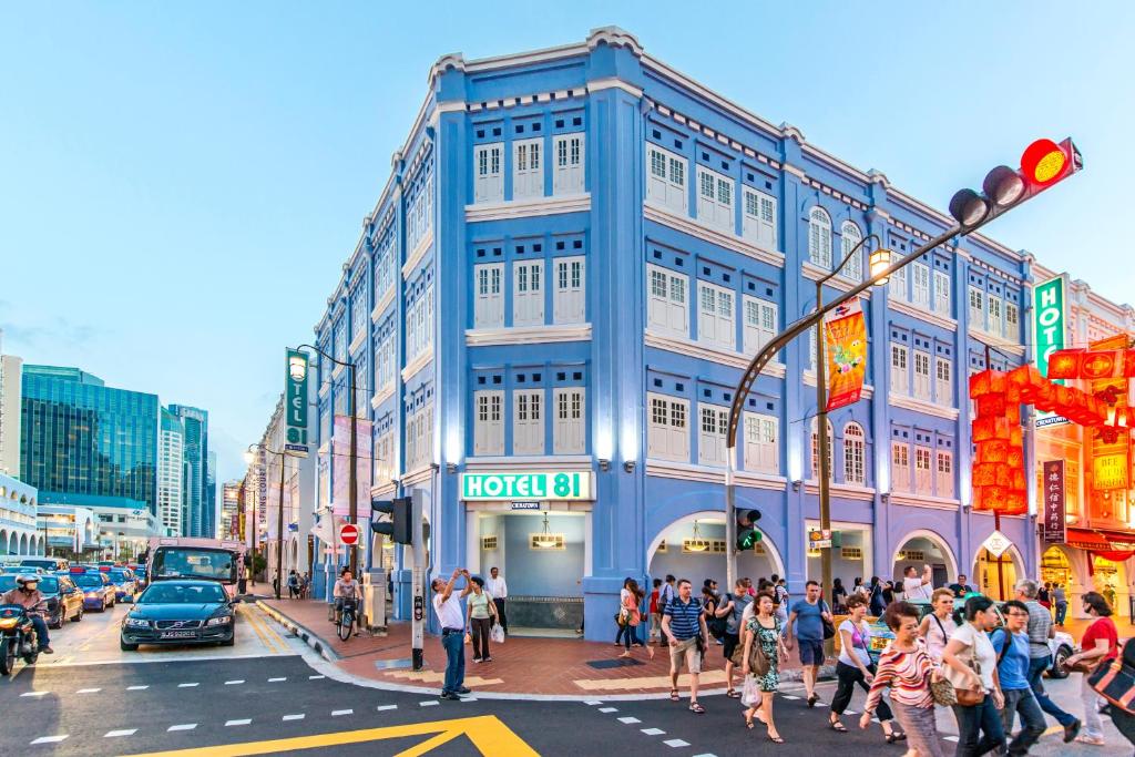 um grupo de pessoas atravessando uma rua movimentada em uma cidade em Hotel 81 Chinatown em Singapura