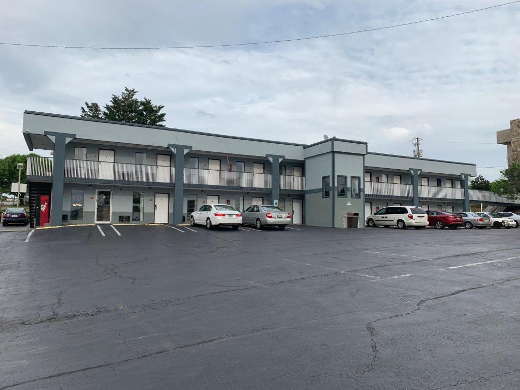 un gran edificio con coches estacionados en un estacionamiento en Royal Inn & Suites, en Knoxville