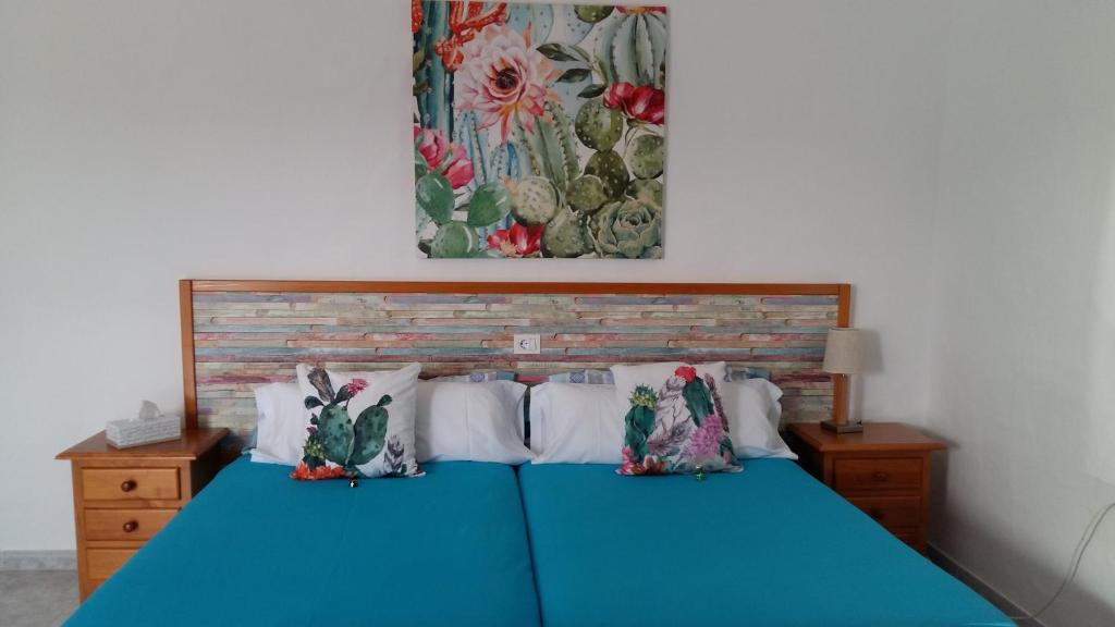 Una cama azul con dos almohadas encima. en Estudio La Calzada en Villaverde