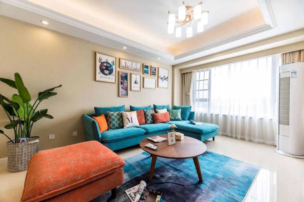 ein Wohnzimmer mit einem blauen Sofa und einem Tisch in der Unterkunft Chengdu Shuangliu·Shuangliu Airport Locals Apartment 00168830 in Shuangliu