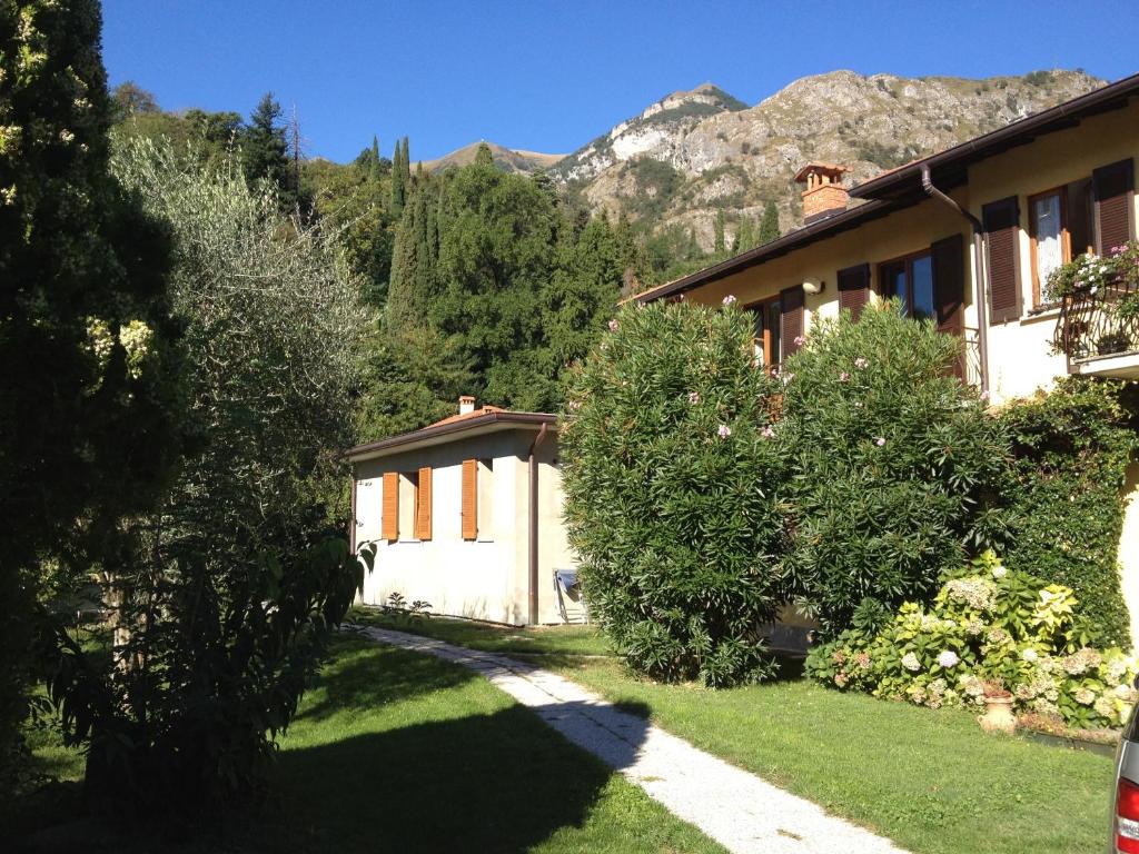 una casa con alberi e una montagna sullo sfondo di Casa Pini a Griante Cadenabbia
