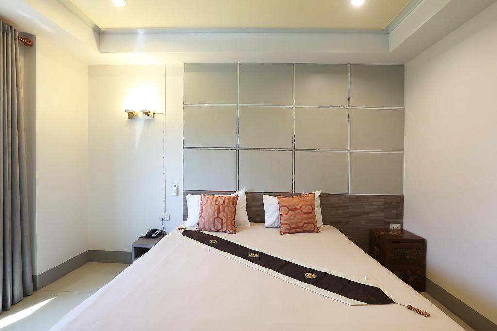 a bedroom with a large white bed with pillows at V Place Residence in Songkhla