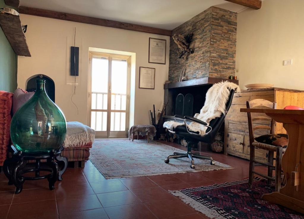 a living room with a fireplace and a chair at Relais Borgo Poggetello in Tagliacozzo