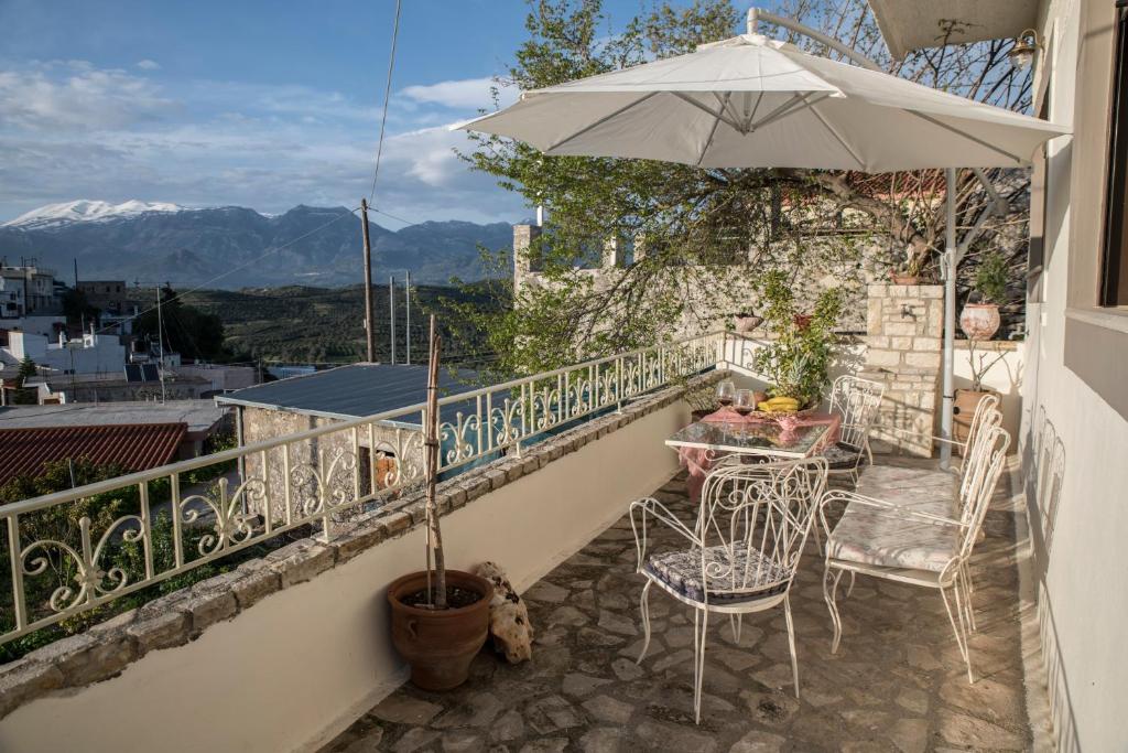 - un balcon avec un parasol, une table et des chaises dans l'établissement Bella Vista Apartment, à Kamilárion