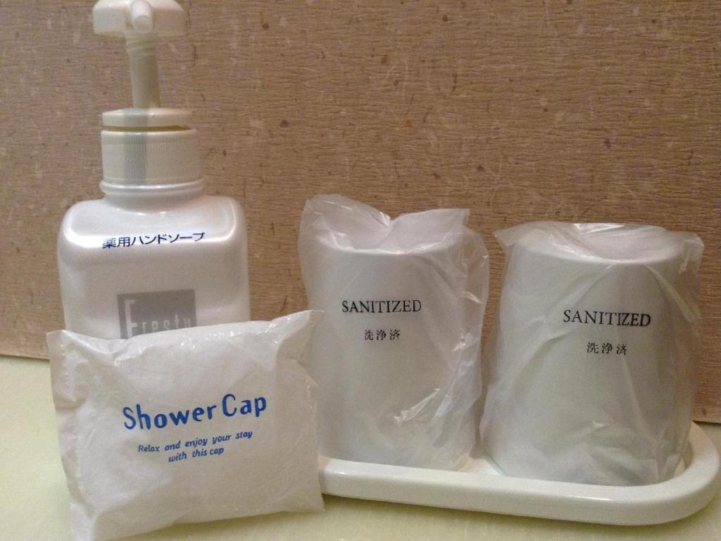 a white tray with a shower cap and a bottle of sunscreen at Inatori Tokai Hotel Yuen in Higashiizu