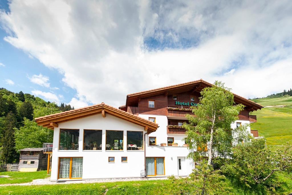 een huis in het midden van een veld bij Hotel Cuntera in Curaglia