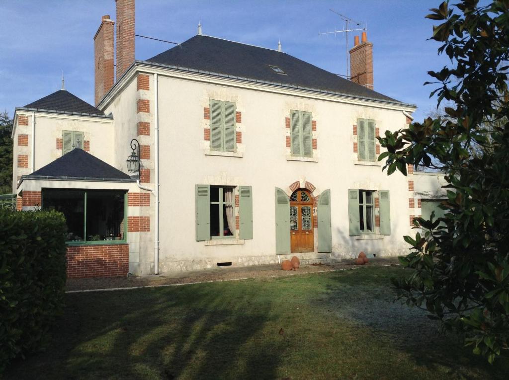 stary biały dom z drzwiami i ogródkiem w obiekcie aux coeurs de l'atelier w mieście Menars